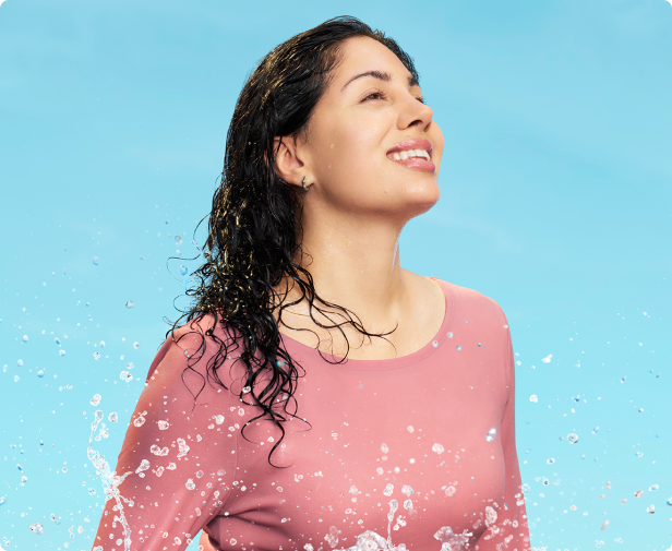 Video thumbnail of SKINVIVE™ patient Nadia smiling as she is  splashed with water, with her skin looking smooth and radiant.
